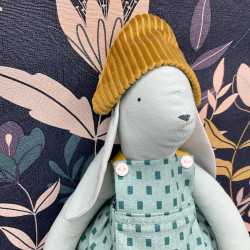 Oracio le lapin habillé d'un pantalon de velours et d'un tablier